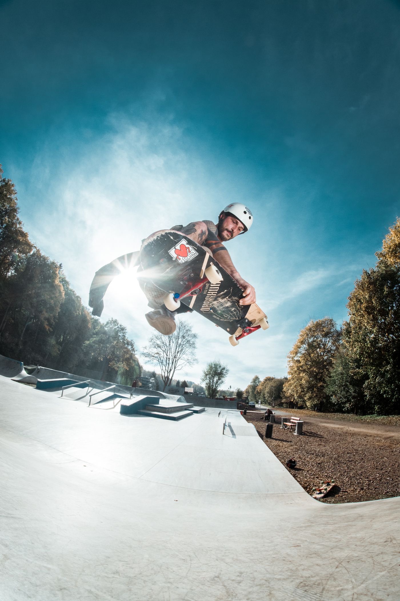 Skateboarder mid-air grab trick at a skatepark