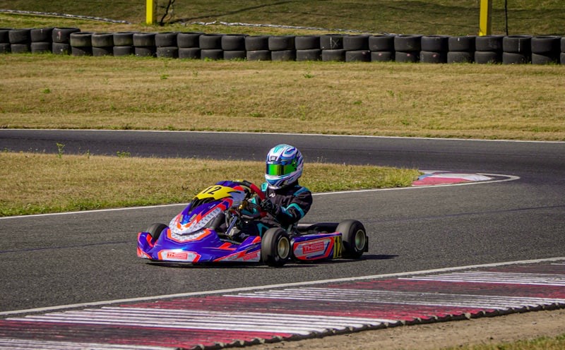 Go-kart racer taking a turn on a paved circuit